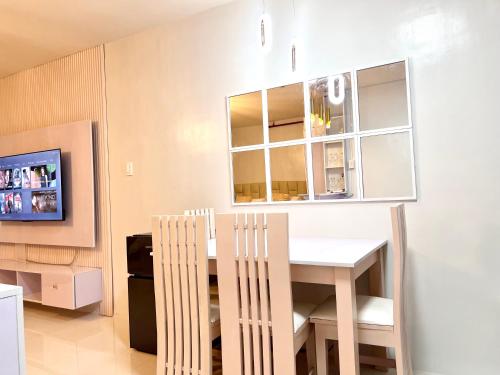 a dining room with a white table and chairs at Cozy Condo Unit in Puerto Princesa City near PPS Airport in Puerto Princesa City