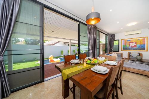 拉威海灘的住宿－Sanook Villas -Geng Mak Nai Harn，一间带桌子和沙发的用餐室