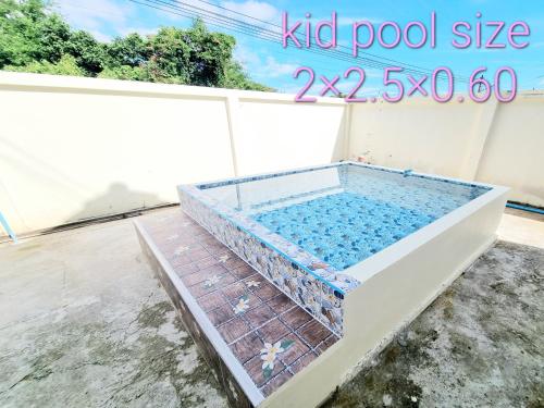 uma piscina num quintal com piso em azulejo em Mae Rampung Beach House คาราโอเกะและสระเด็ก em Rayong