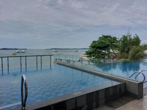 a large swimming pool with a view of the water at Batam Two Bedrooms Apartment - One Residence 25AJ in Batam Center