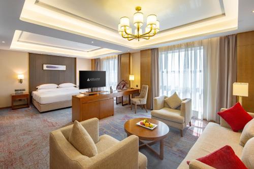 a hotel room with a bedroom and a bed at Wan Yue Grand Skylight Hotel in Bao'an