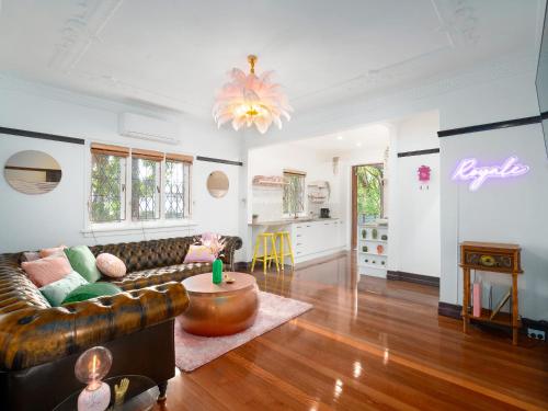 a living room with a leather couch and a table at Anville Court in Brisbane