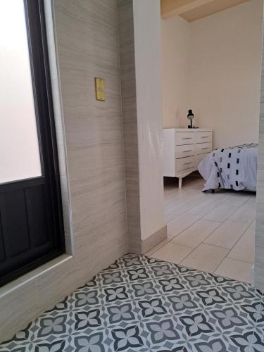 Habitación con ducha a ras de suelo junto a un dormitorio en Habitación Chalini, en Cholula