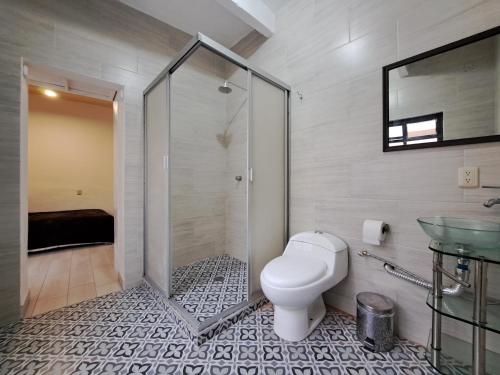 een badkamer met een douche, een toilet en een wastafel bij Habitación Chalini in Cholula