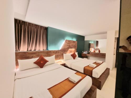 una camera d'albergo con due letti e un tavolo di Cozi Inn Hotel, Bangkok a Bangkok