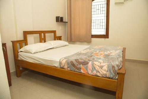 a bedroom with a bed in a room with a window at IZI APOLLO STAY in Chennai