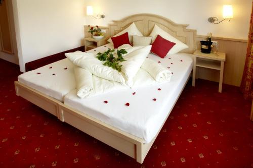 a bedroom with a large white bed with red carpet at Kamptalschlössl in Plank am Kamp