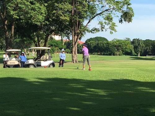 un groupe de personnes jouant au golf dans un parc dans l'établissement Jatuporn A1, à Pathum Thani