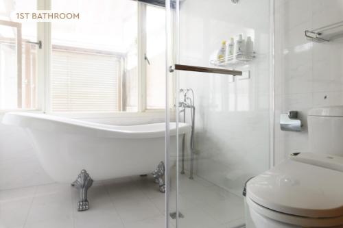 a white bathroom with a tub and a toilet at 5B3b Dream Home 3min to Tech Building MRT 夢想之家 5房3衛 3分到科技大樓 in Taipei