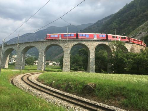 a train on a bridge with a train on it at Osteria Del Centro in Brusio