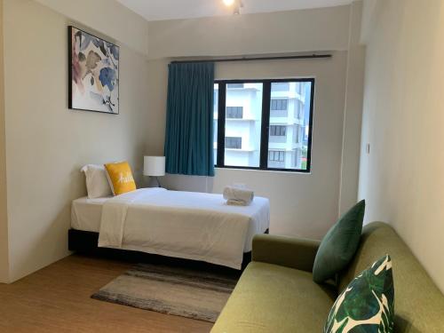 ein Schlafzimmer mit einem Bett, einem Sofa und einem Fenster in der Unterkunft Urban Living Residence in Kuala Lumpur