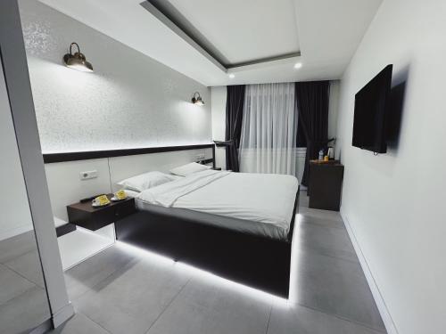 1 dormitorio con cama con sábanas blancas y luz en Kadıköy Duck hotel, en Estambul