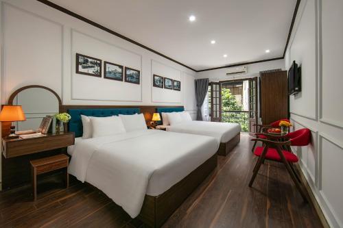 a hotel room with two beds and a television at Silk Hanoi Moment Hotel & Spa in Hanoi