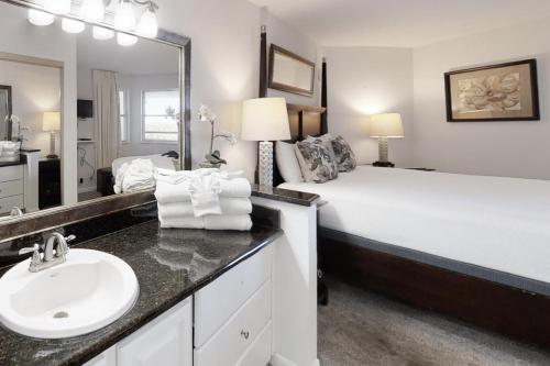een badkamer met een bed, een wastafel en een spiegel bij Perdido Sun 1104 in Perdido Key