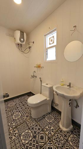a bathroom with a toilet and a sink at White Lotus Villa in Pune