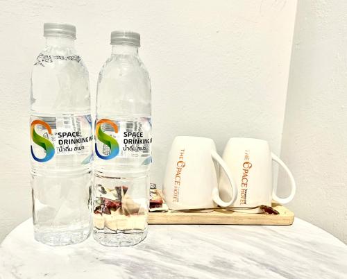 two bottles of water sitting on a table at The Space Hotel Lampang in Lampang