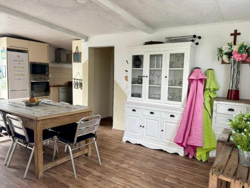 a kitchen with a table and a cross on the wall at Maison vue mer chaleureuse et confortable in Petite Île