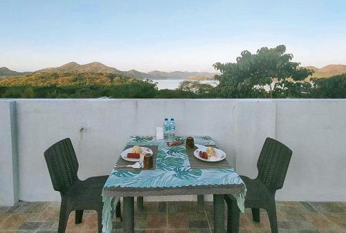 een tafel met borden eten op een balkon bij RedDoorz @ Recson Hostel Coron Palawan in Coron