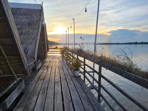 a wooden dock with plants on it next to the water at Savet Guesthouse in Stœ̆ng Trêng