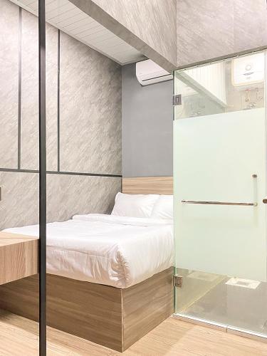 - une chambre avec un lit et un mur en verre dans l'établissement DJURAGAN KAMAR SUHAT, à Kasri