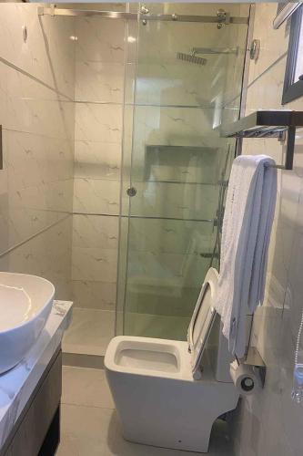 a bathroom with a toilet and a glass shower at Castle Estate Apartments 3 in Abuja