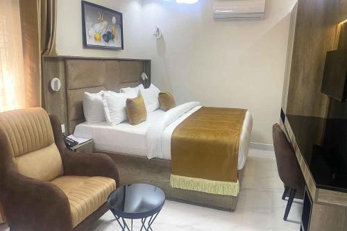 Pokój hotelowy z łóżkiem i krzesłem w obiekcie Castle Estate Apartments 3 w mieście Abudża