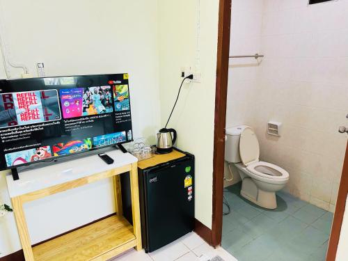 een badkamer met een toilet en een zwarte koelkast bij K.L.Apartment in Chalong 
