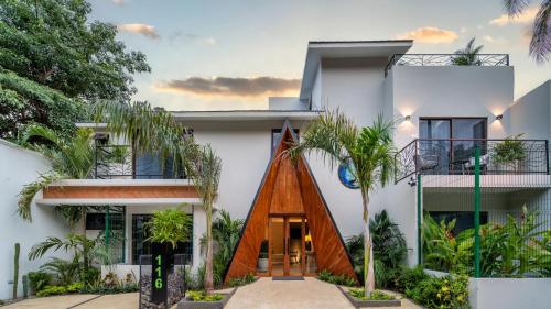 a house with a wooden door and palm trees at Casa Blú Huatulco in Santa Cruz Huatulco