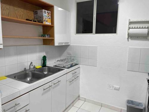 a white kitchen with a sink and a window at Exclusivo apartamento in San Salvador