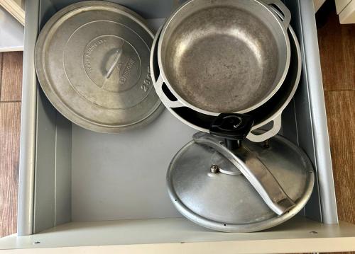 two pots and pans sitting on top of a shelf at Maison vue mer chaleureuse et confortable in Petite Île