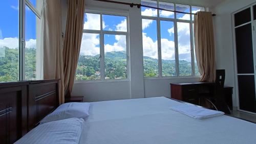 a bedroom with a bed and large windows at Smile Hub Kandy in Kandy