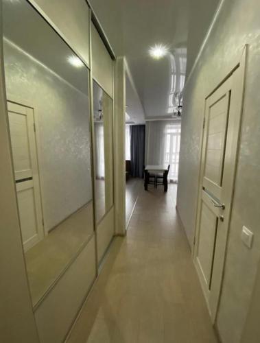 un pasillo con 2 espejos y un banco en una habitación en City Centre Vip 220, en Tiflis