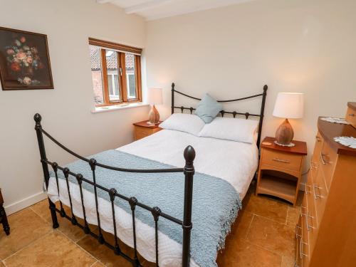 um quarto com uma cama preta e um cobertor azul em The Granary em Askham