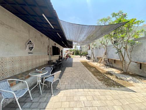 patio con tavoli e sedie su un marciapiede di Timaya Villa a Legian