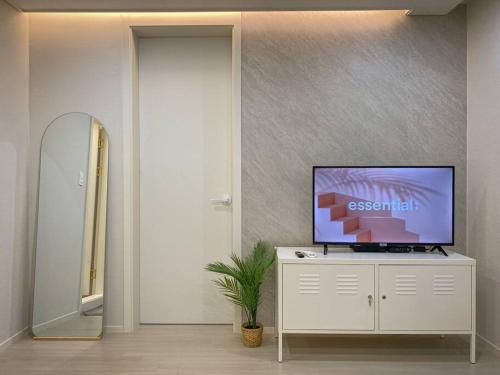 a living room with a television on a white cabinet at Stay Light in Seoul