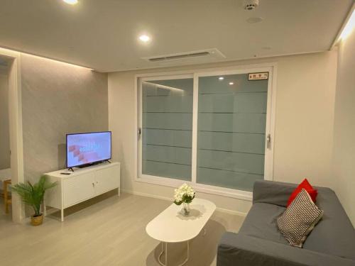salon z kanapą i telewizorem w obiekcie Stay Light w Seulu