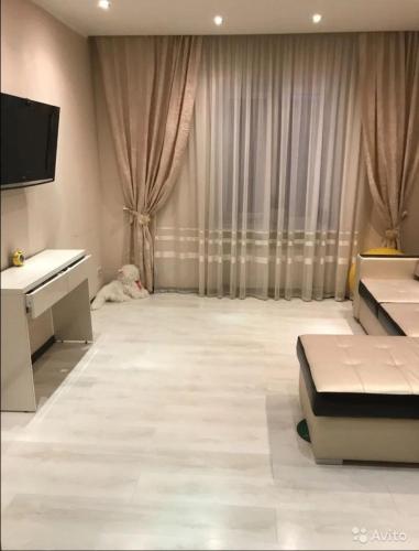 a living room with a couch and a tv and a room with at City Centre Vip 218 in Tbilisi City