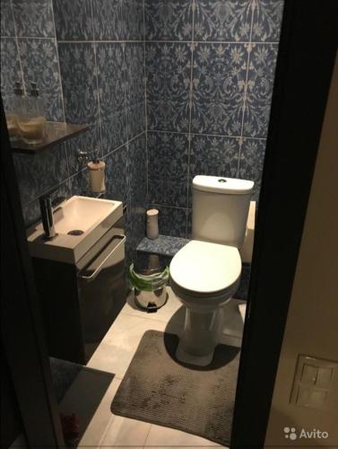 a bathroom with a white toilet and a sink at City Centre Vip 218 in Tbilisi City