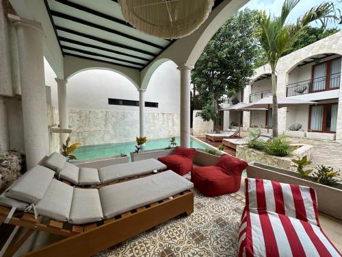 a patio with a bed and a couch and a pool at Los Frailes Concept Hotel in Valladolid