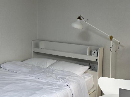a bedroom with a white bed and a lamp at M Stay Near Mokdong Station in Seoul