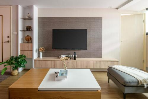 a living room with a tv on a wall at 4B2b Clear Comfort 3min to Xinyi Anhe MRT 4房2衛 舒適明亮之家 3分到信義安和站 in Taipei