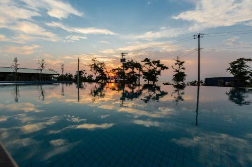 an empty swimming pool with a sunset in the background at Peekaboo in Xiaoliuqiu