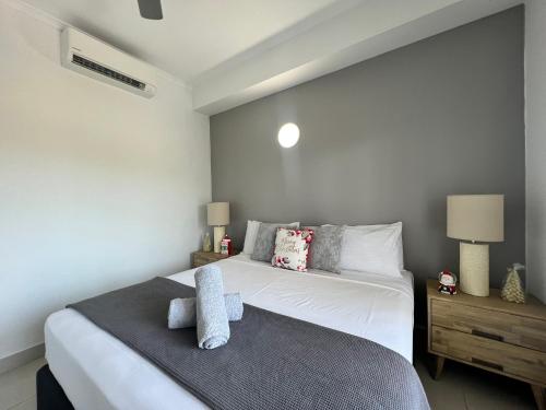 1 dormitorio con 1 cama blanca grande y 2 lámparas en Marina View Holiday Apartment - Beautiful Views, en Larrakeyah