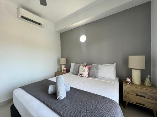 Un dormitorio con una gran cama blanca y dos lámparas. en Marina View Holiday Apartment - Beautiful Views, en Larrakeyah