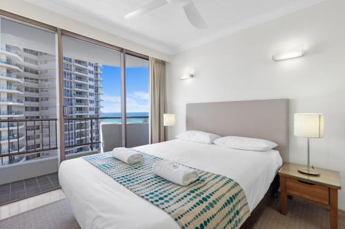 a bedroom with a bed and a large window at Pacific Resort Broadbeach in Gold Coast