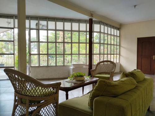 a living room with a couch and chairs and a table at The Garden Family Guest House powered by Cocotel in Bogor