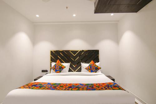een slaapkamer met een groot bed met witte lakens bij FabHotel Greysky in New Delhi