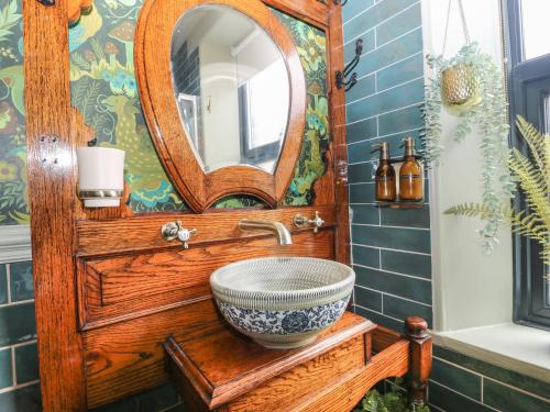 a bathroom with a wooden sink and a mirror at Emerald Cottage in Keighley