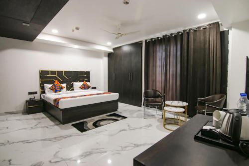 a bedroom with a bed and a desk and chairs at FabHotel Sky Suites Karkardooma in New Delhi