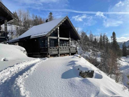 una cabina nella neve con un mucchio di neve di Cabin with a great view at Gaustablikk a Gaustablikk
